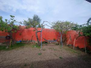 ein Schlagkäfig vor einer roten Wand in der Unterkunft Lo de Juana in Puerto Madryn