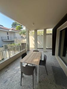 a patio with a wooden table and chairs on a balcony at Colle del Mare in Gabicce Mare