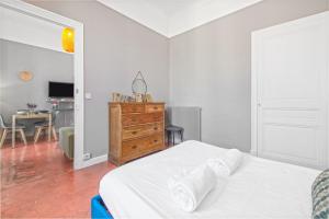 a bedroom with a bed and a dresser and a desk at Le charme au coeur de Menton! in Menton +12 photos