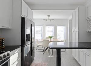 a white kitchen with a table and a dining room at 20 min to NYC, Newly Renovated, Private Driveway in Little Ferry +16 photos