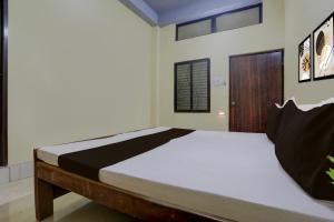 une chambre avec un grand lit dans une pièce dans l'établissement SPOT ON by OYO Hotel Sun City, à Prayagraj