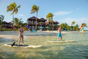 two men are standing on surfboards in the water at X'tan Ha- The Waterfront in San Pedro