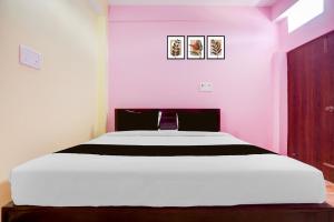 Un dormitorio con una cama blanca con paredes moradas en SPOT ON Hotel Chandi, en Bihār Sharīf 19 fotos más