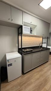 an empty kitchen with a microwave and a refrigerator at Residencial Roberto Luiz Chiodi in Campos Novos