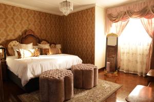 a bedroom with a large bed with a white bedspread andngthngthngthngth at GBL Reine Chateau in Polokwane