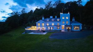 a large blue house with its lights on at Craig y Don in Menai Bridge