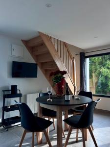 una sala da pranzo con tavolo, sedie e scala di Les Gîtes de la Source de la Loire a Sainte-Eulalie