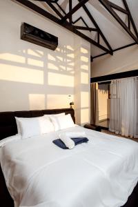 a white bed with two towels on top of it at The Pinnacle Polokwane in Polokwane +45 photos
