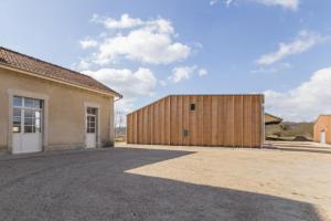 ein Haus mit einer Holzgarage neben einem Gebäude in der Unterkunft Gîte de la Gare 3 in Voulaines + 6 Fotos