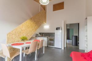 eine Küche und ein Esszimmer mit einem weißen Tisch und Stühlen in der Unterkunft Gîte de la Gare 3 in Voulaines