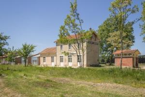 ein altes Gebäude mit einem Silo davor in der Unterkunft Gîte de la Gare 3 in Voulaines