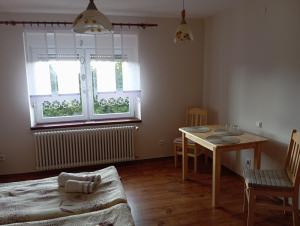 a living room with a table and a table and chairs at Agroturystyka Agro Greupner in Jemielnica