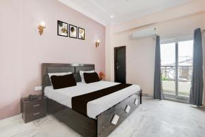 a bedroom with a large bed and a large window at Hotel O RR Palace Hotel & Banquet in Bhauli