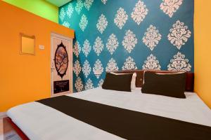 a bedroom with a large bed with orange and blue walls at SPOT ON Surya Hotel in Handiā +69 photos