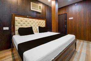 BādshāhnagarにあるHotel O Royal Inn Hotelの木製の壁のベッドルーム1室(白い大型ベッド1台付)