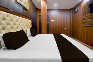 BādshāhnagarにあるHotel O Royal Inn Hotelの大きなベッドと木製の壁が備わるベッドルーム1室が備わります。 +21枚の写真