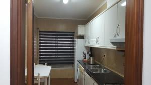 a small kitchen with white cabinets and a sink at Apartamento Moderno e Elegante in Ponta Delgada +16 photos