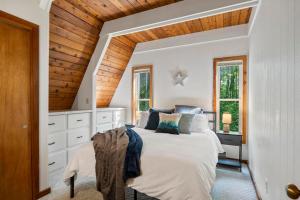 Un dormitorio con una cama blanca y un techo de madera. en Hansel Htte Cozy A-frame At Schuss Mountain, en Bellaire 42 fotos más