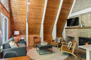 Una sala de estar con un sofá y una chimenea. en Hansel Htte Cozy A-frame At Schuss Mountain, en Bellaire