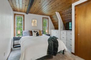 a bedroom with a large white bed and a tv at Cozy A-frame Cabin At Schuss Mt Ski, Golf in Bellaire +42 photos