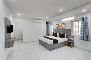 a bedroom with a bed and a flat screen tv at HOTEL O MURARI in Karīmnagar