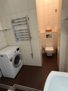a bathroom with a washing machine and a toilet at Квартира в центре in Dnipro