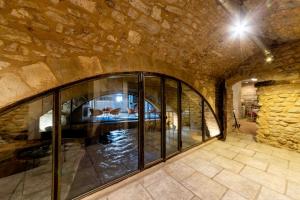 a room with a large glass window in a stone wall at La Prévôté - Luxury Chambres d'hôtes & Gastronomic Restaurant in L'Isle-sur-la-Sorgue