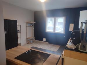 a kitchen with a stove top oven in a room at Parfaite pour toutes direction in Fenain +2 photos