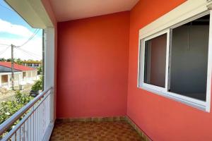 a balcony with an orange wall and a window at Villa Kaz a Ramon in Port-Louis