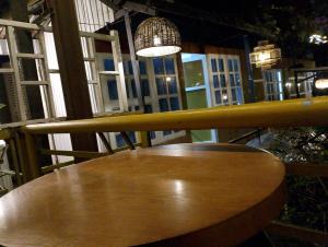 un tavolo di legno su un balcone con una lampada e delle finestre di Vuong Tran Dalat Inn Retreat a Da Lat