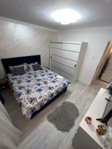 a bedroom with a bed with a blue and white comforter at Relax Loft in Oradea