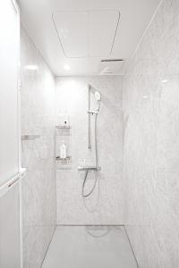 a white bathroom with a shower with a glass door at Unite Stay Gyotoku in Tokyo +46 photos