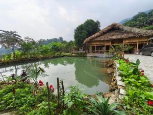 a house with a pond in front of it at Hagiang Joy's retreat 