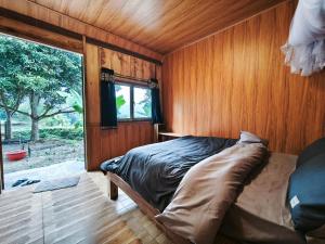 a bedroom with a bed in a wooden wall at Hagiang Joy's retreat 