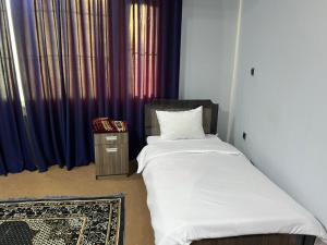 a bedroom with a bed and a night stand and a window at Star Shirpoor Guest House in Kabul +14 photos