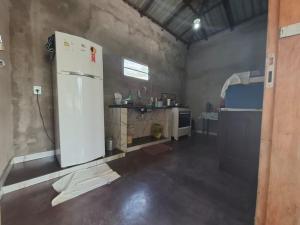 a kitchen with a white refrigerator in a room at Casa Brisa do Tapajós in Santarém