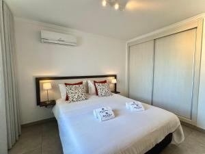 a bedroom with a large white bed with two pillows at Pérola do Oceano in Manta Rota +38 photos
