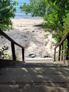a staircase leading to a sandy beach with the ocean at Casa Brisa do Tapajós in Santarém