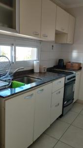 eine Küche mit weißen Schränken und einer Spüle in der Unterkunft Como en casa in Corrientes + 11 Fotos