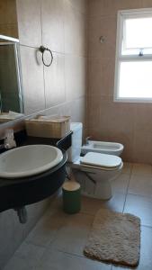 ein Badezimmer mit Waschbecken, Toilette und Fenster in der Unterkunft Como en casa in Corrientes
