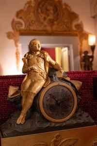 eine Statue eines Mannes, der auf einer Uhr sitzt in der Unterkunft Giordano Segreto in Rom