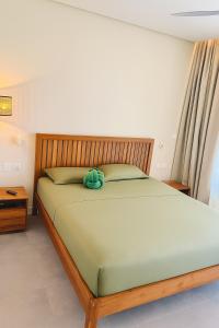 a bedroom with a bed with a green comforter at Asmara Mauritius Oceanfront Retreat in Petite Case Noyale