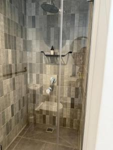a shower with a glass door in a bathroom at Kkape Sands - Peak Views From Sea Point Pad in Cape Town