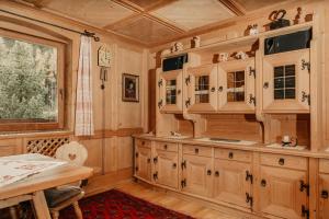 cocina con armarios de madera, mesa y ventana en Apartments Thaler Irina, en Ortisei