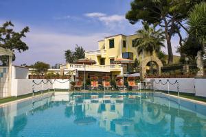 une grande piscine en face d'un bâtiment dans l'établissement Albergo Villa Hibiscus, à Ischia