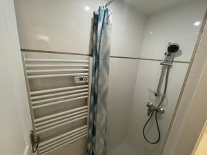 a shower in a bathroom with a glass door at Cozy studio ideal for a stay in Bagneux in Bagneux