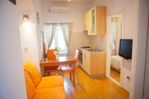 a small kitchen and dining room with a table and a couch at Summer Lounge Apartments in Split