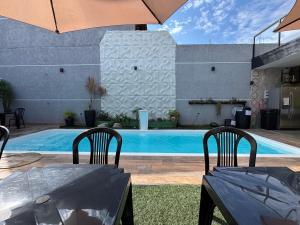 a pool with two chairs and a table with an umbrella at Espaço Varanda in Sao Paulo