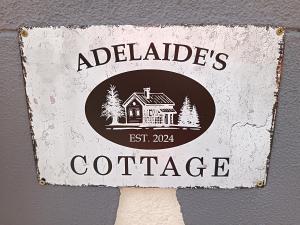 un cartello con la scritta Adelaides Cottage su un muro di Adelaide's Cottage a Ponta do Pargo