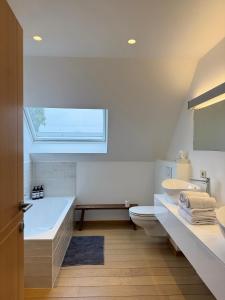 ディクスムイデにあるBiervlietmolen Vakantiewoningの浴槽、トイレ、洗面台を備えたバスルーム